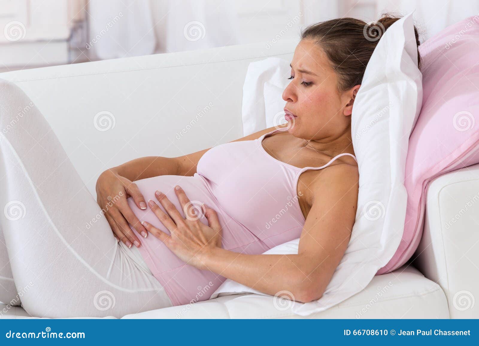 pregnant woman getting a contraction at home in the living room
