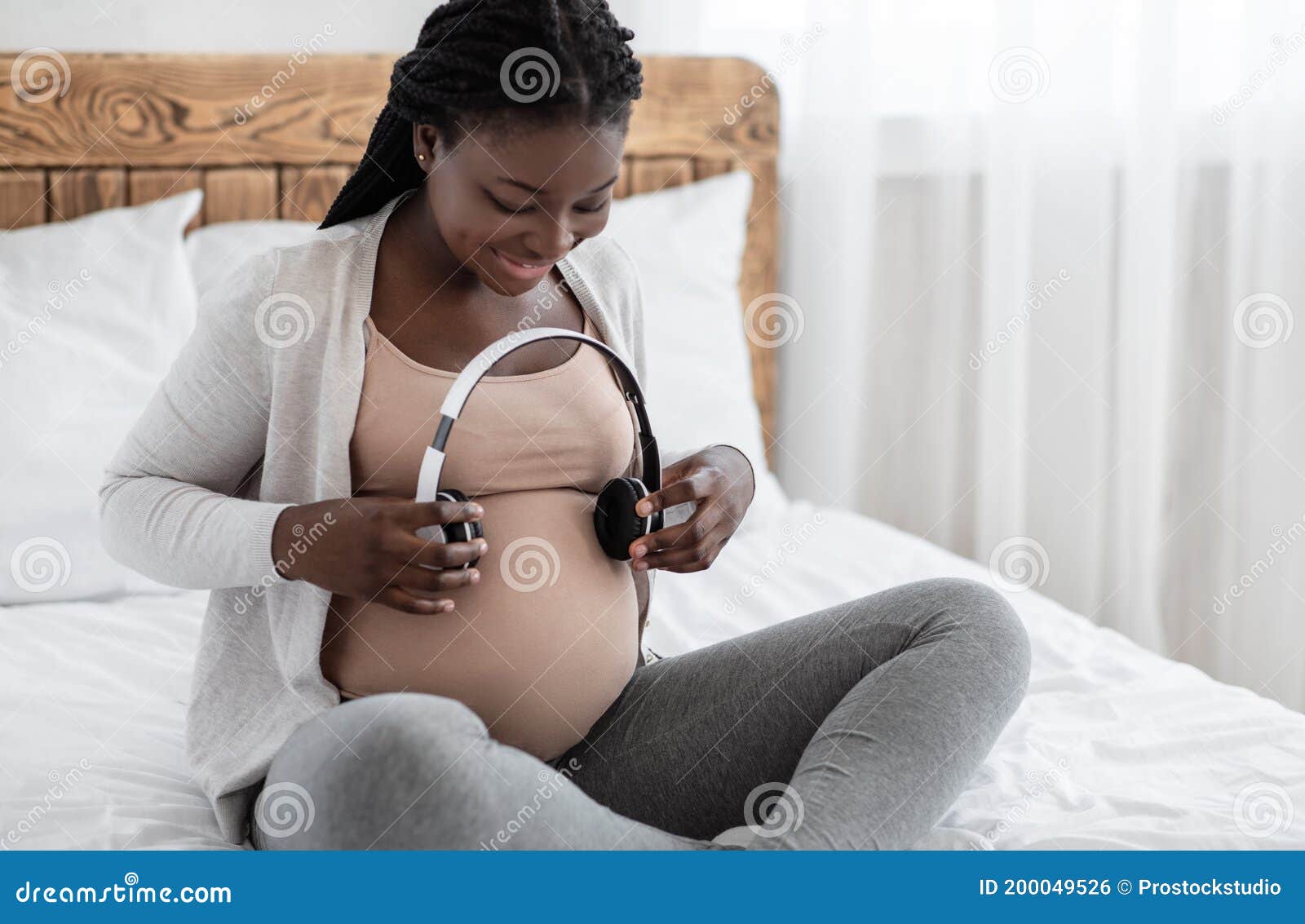 Pregnant Woman Holding Headphones Near Belly, Playing Melody To Baby in Womb  Stock Photo - Image of adult, family: 200049526