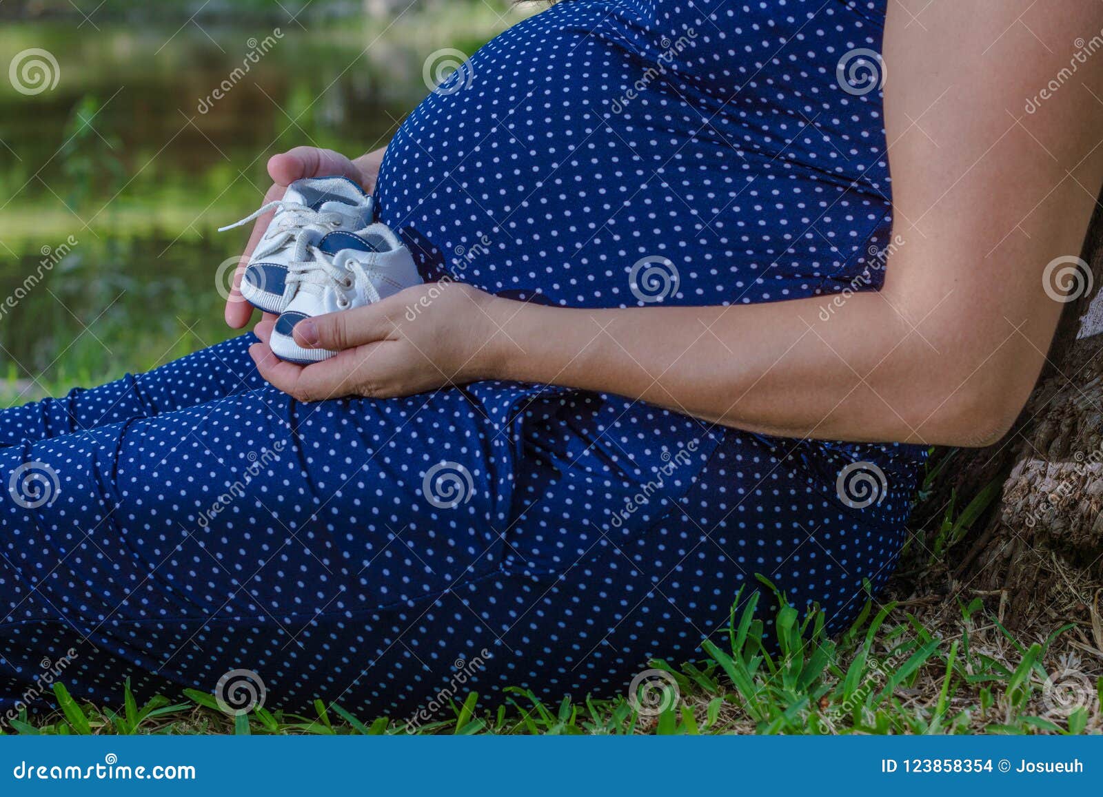 pregnant woman holds her son`s shoes