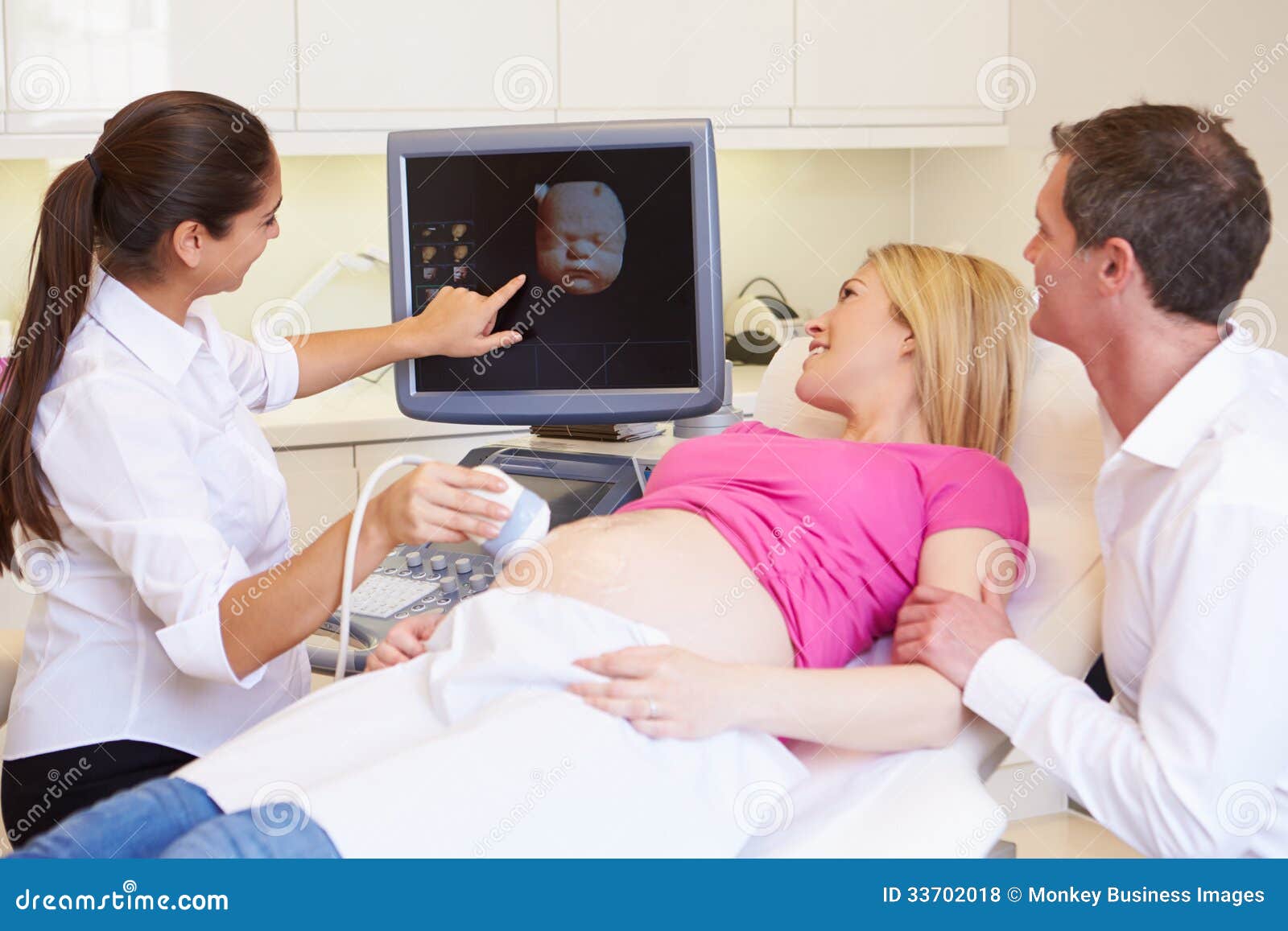 Pregnant Woman and Partner Having Ultrasound Scan Photo - of excitement, clinic: