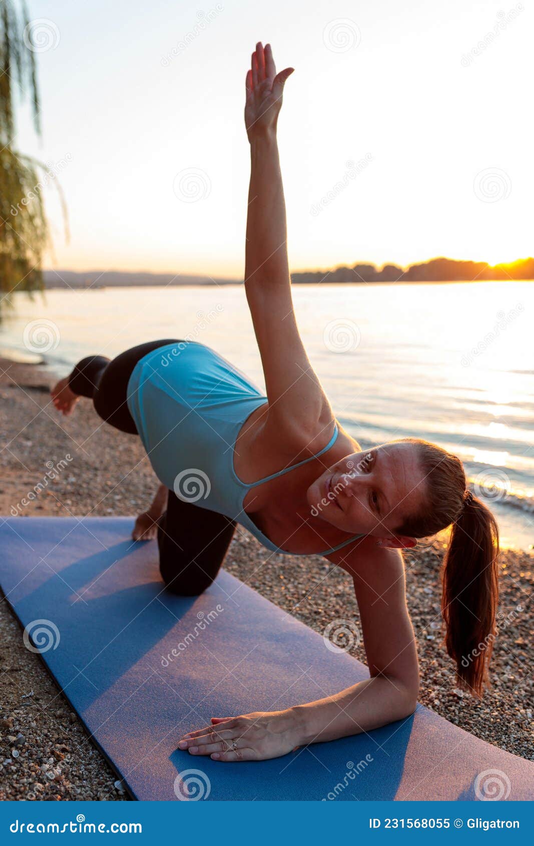 Pregnant Woman Practicing Prenatal Yoga on Beach at Sunset Stock