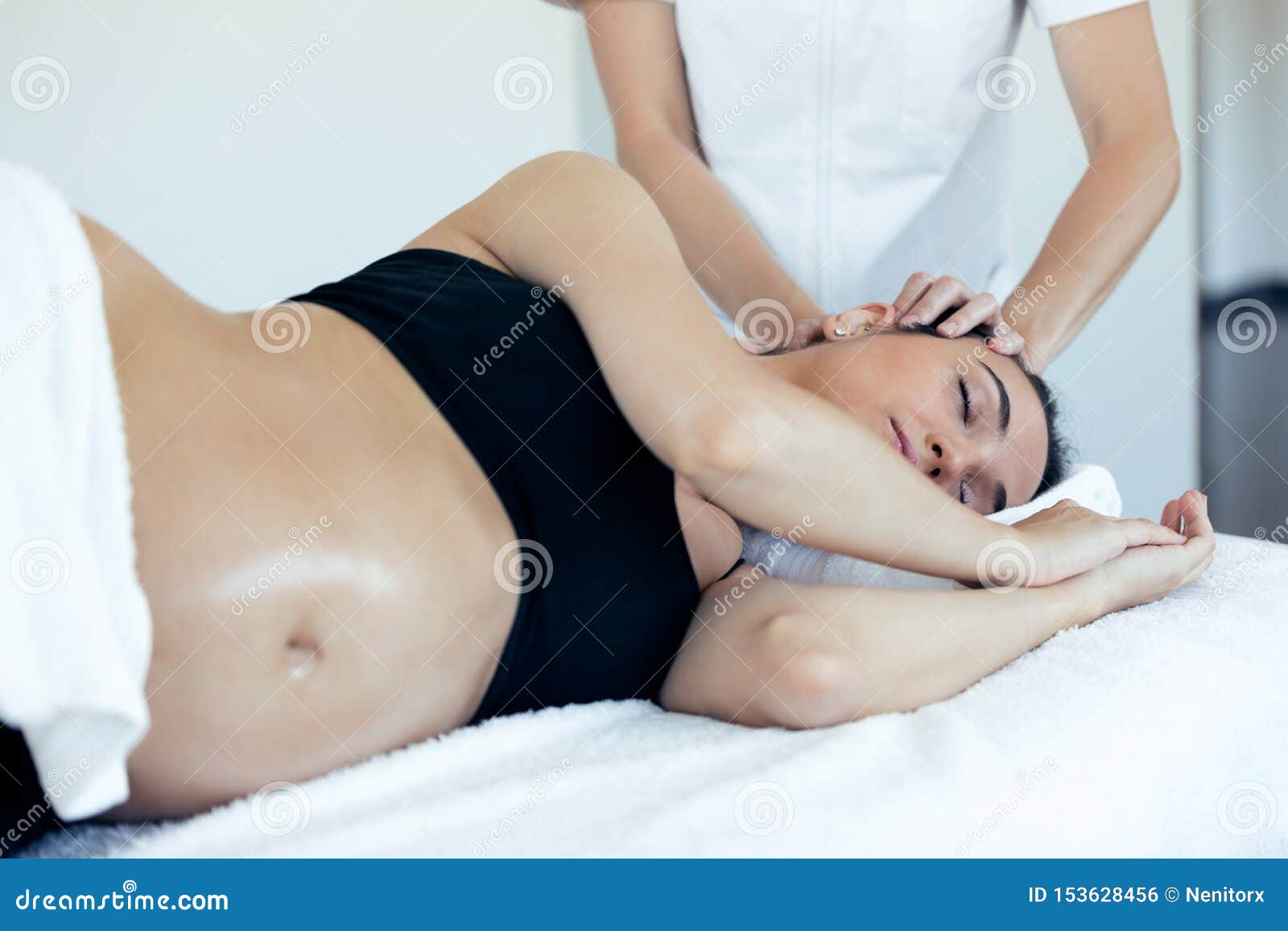 pregnant woman receiving osteopathic or chiropractic treatment in neck in a clinic