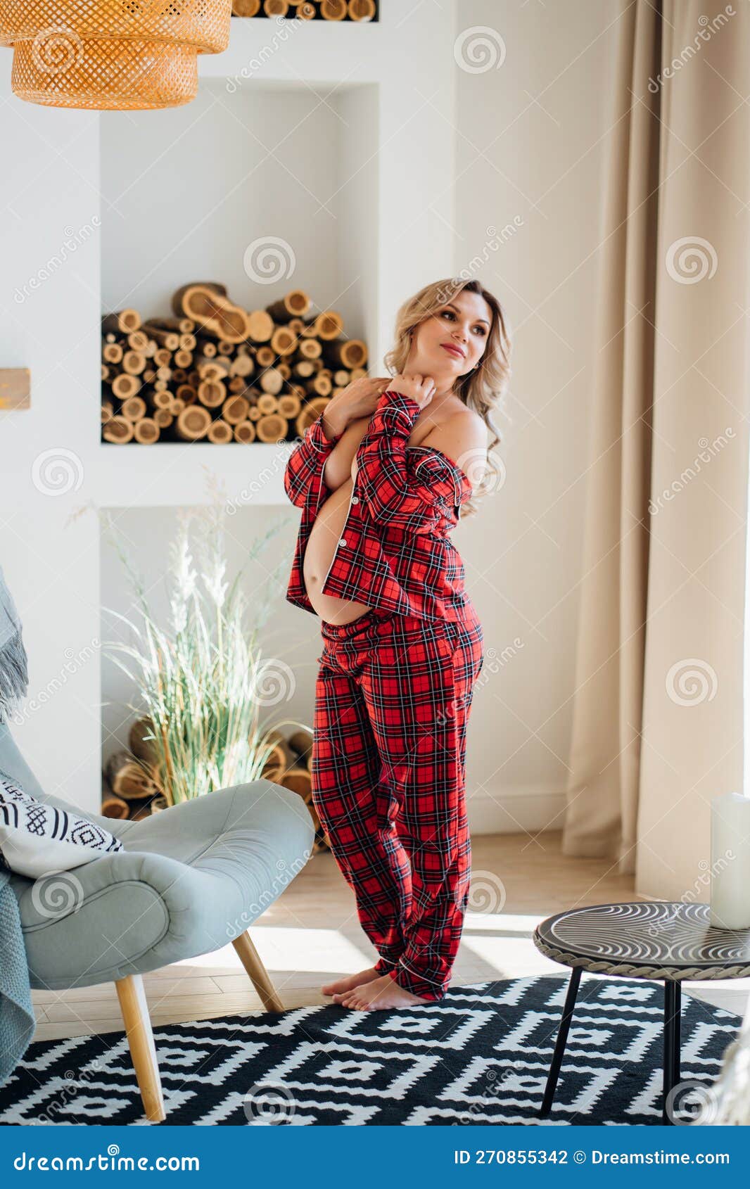A Pregnant Woman Topless in Pajamas in a Home Interior. Stock
