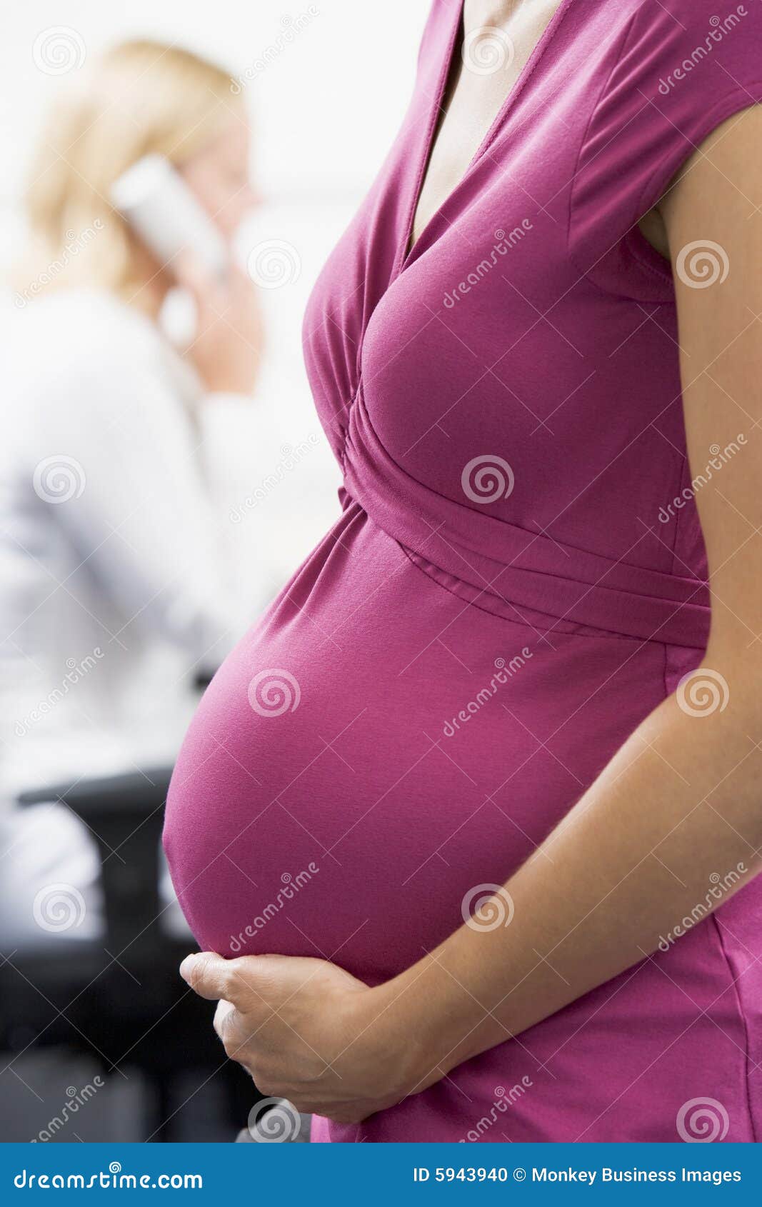 pregnant woman at work holding belly with coworker