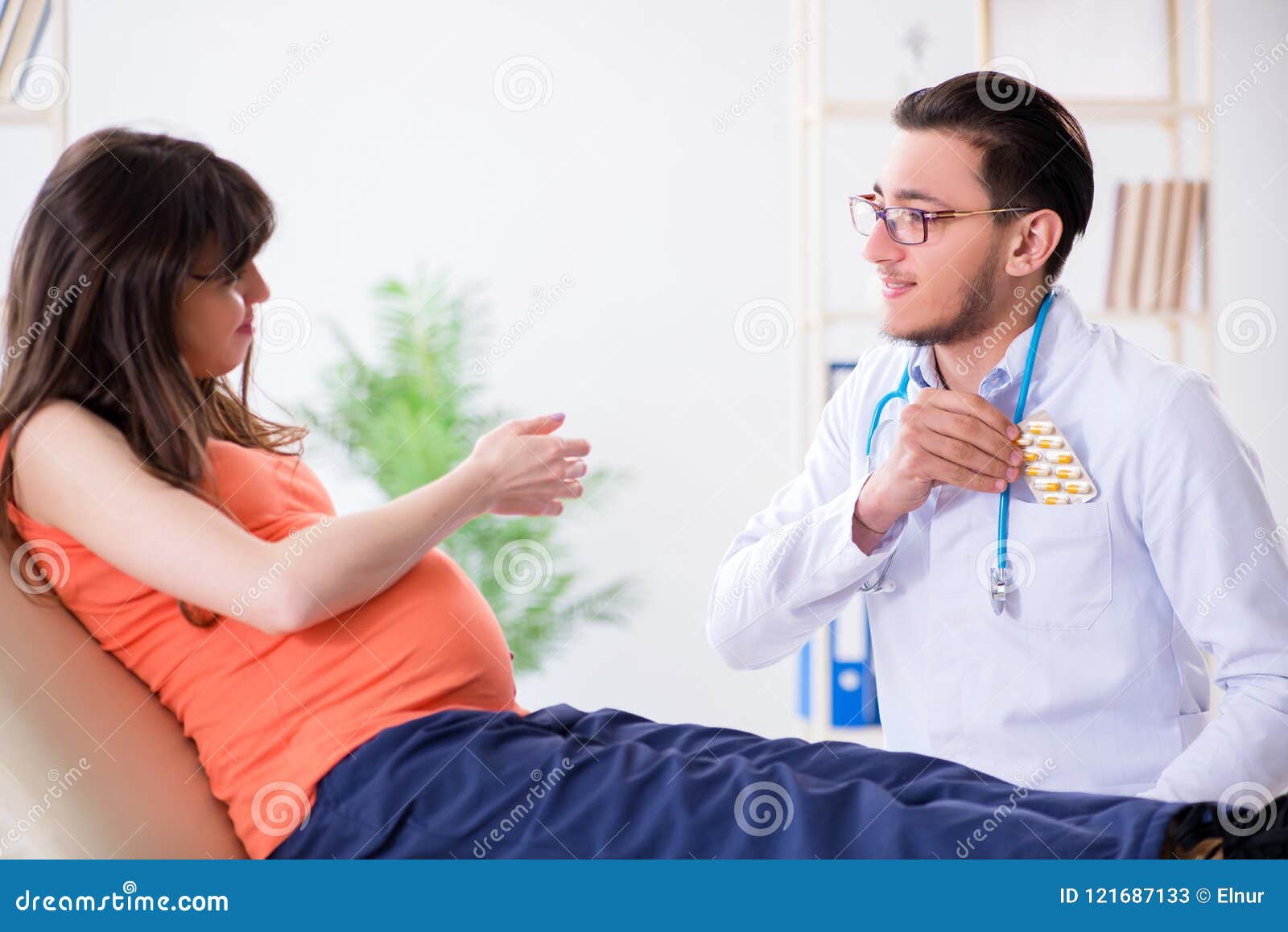 The Pregnant Woman With Her Husband Visiting The Doctor In Clinic Stock