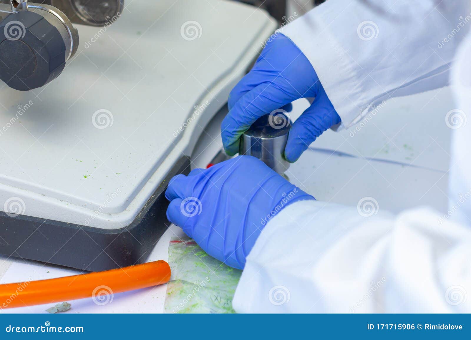 preparation of sample using vibrating mill. woman hands in blue gloves hold green powder sample after oscillating rotary sieve.