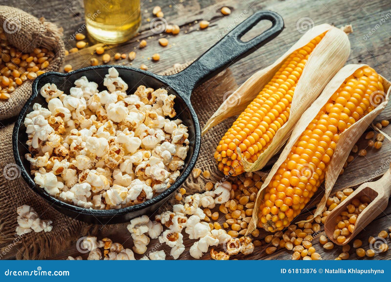 prepared popcorn in frying pan, corn seeds and corncobs