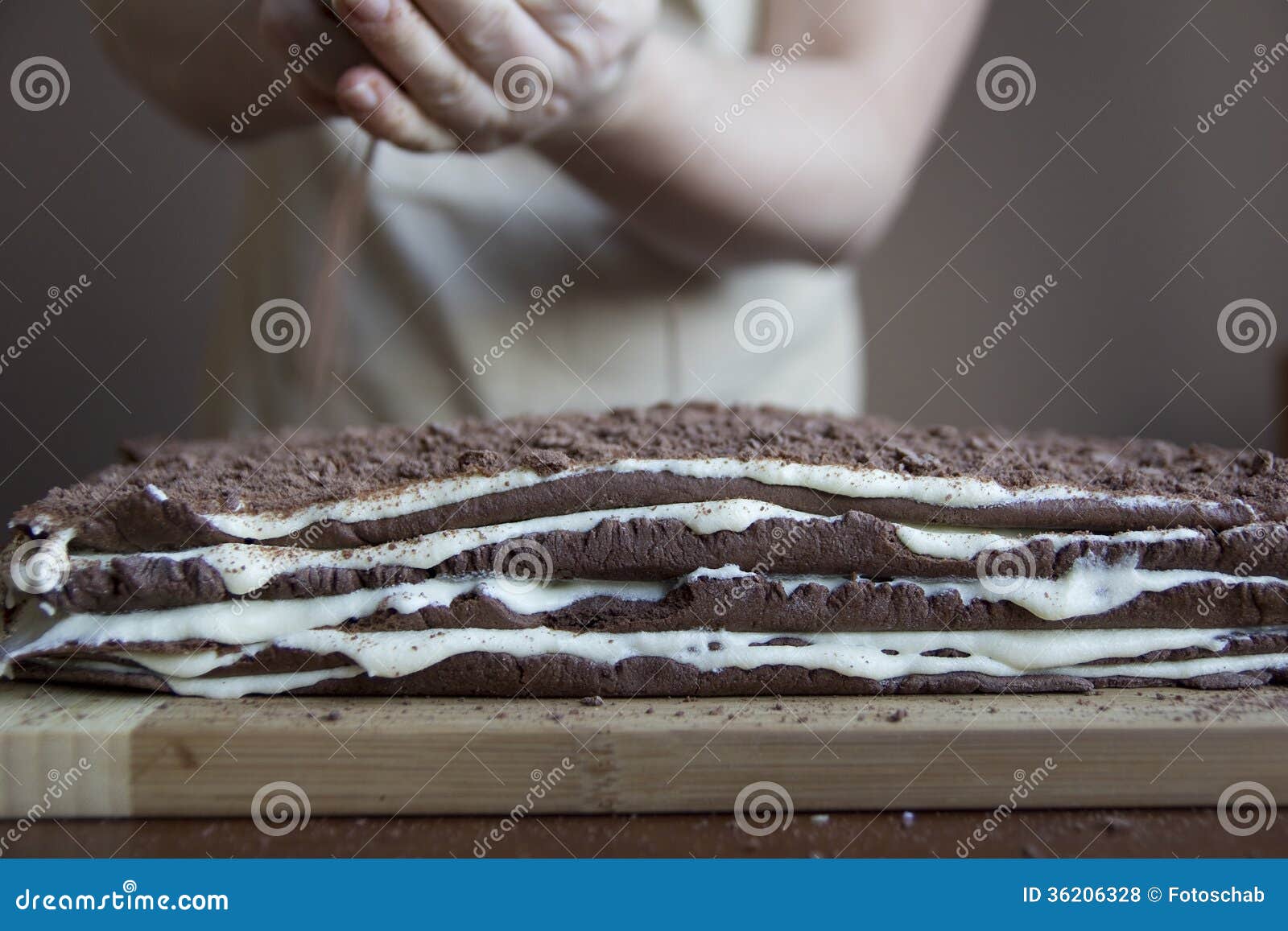 Preparing layer cake. Sprinkling a layer cake, selective focus