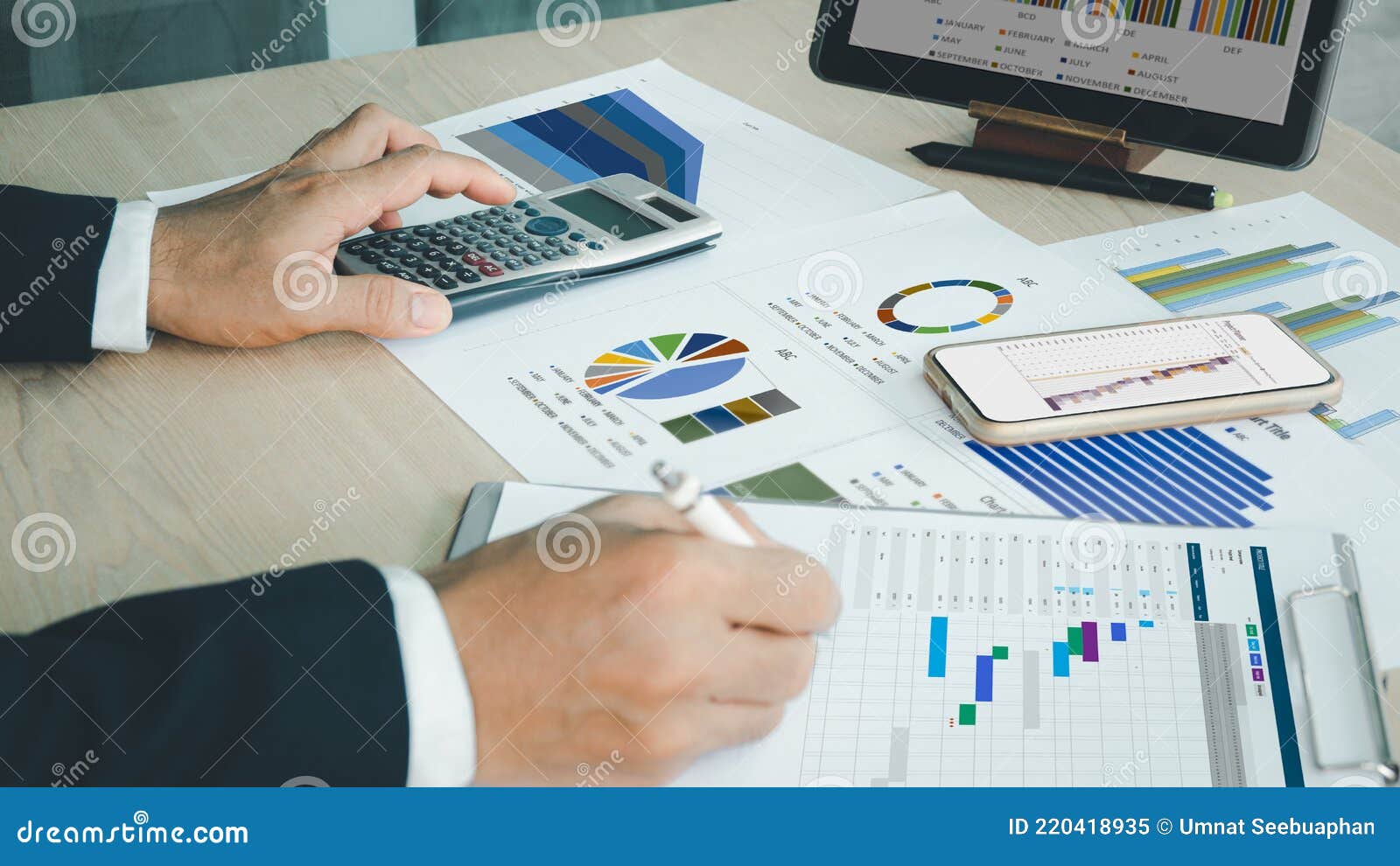 preparing report. green and red graphs and charts. business reports and pile of documents on ash wood top table background
