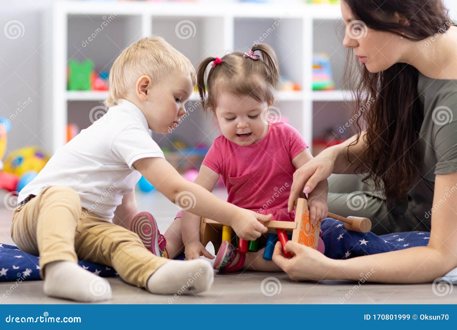 preschooler children playing with educational wooden toys at kindergarten or day care center. toddlers with teacher in