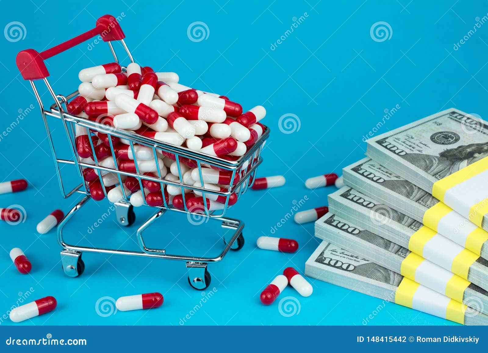 Cost of drugs. prescription drug prices concept. shopping cart filled red medicinal capsules, wad of dollar money, blue background