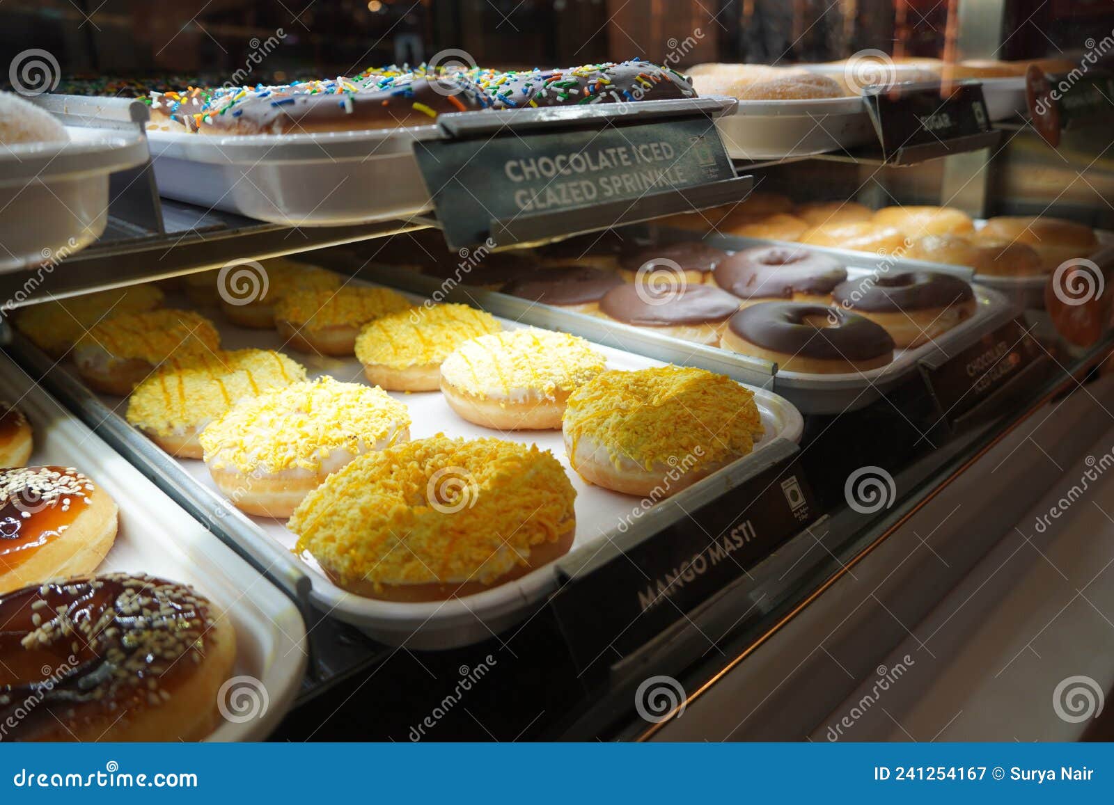 Presentación De Bollería Deliciosa Con Donuts a La Vista En El Mostrador De  La Tienda. Varios Donuts En Un Estante En Una Panaderí Fotografía editorial  - Imagen de mango, helado: 241254167