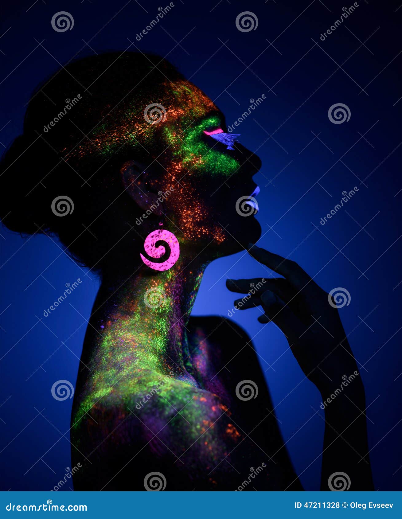 Cara de mujer en la oscuridad con pintura fluorescente maquillaje  sosteniendo un velo blanco bajo las luces negras deep blue Fotografía de  stock - Alamy