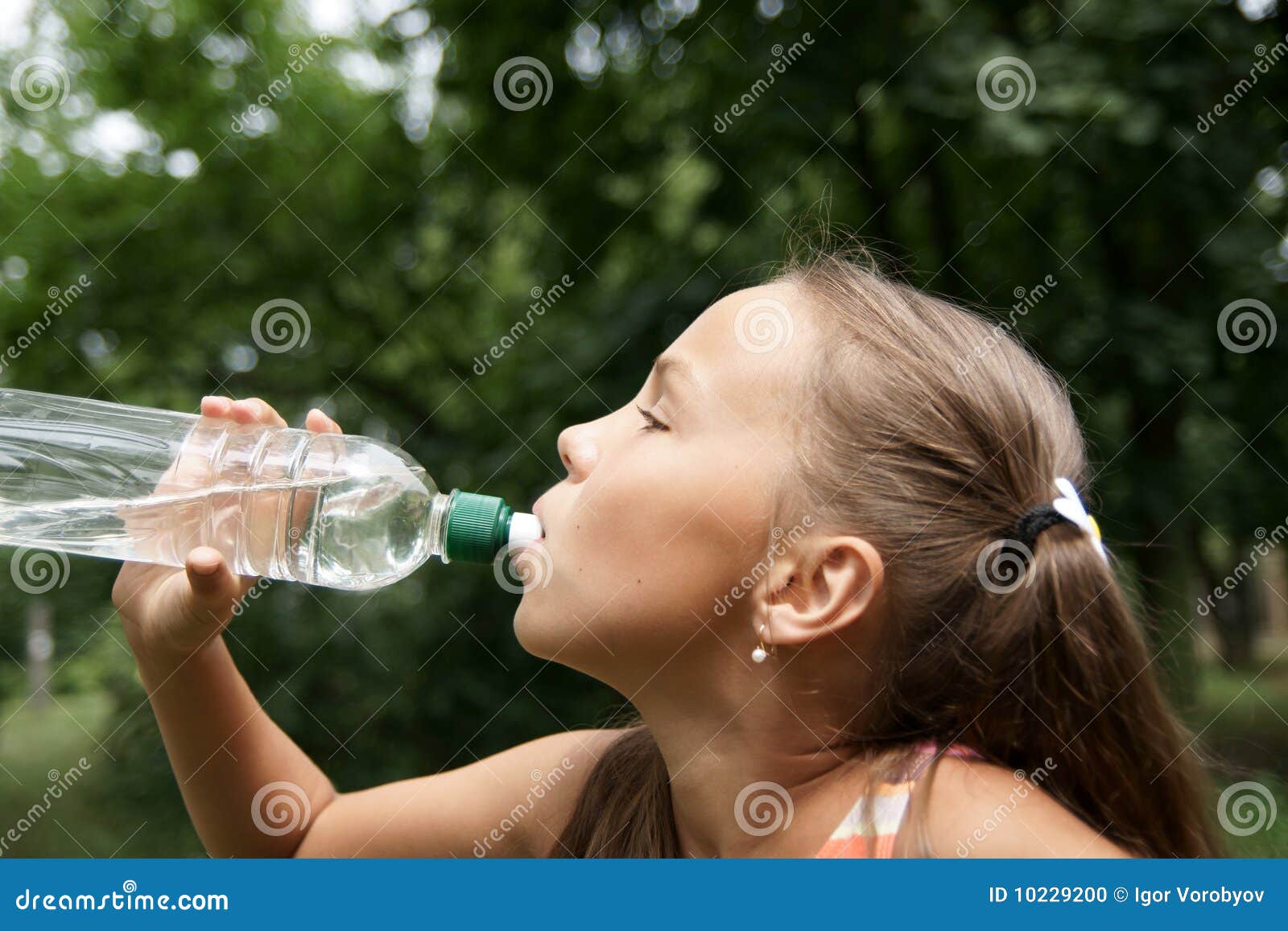 Teenage girl drinks water from bottle Stock Photo by ©BestPhotoStudio  64410247