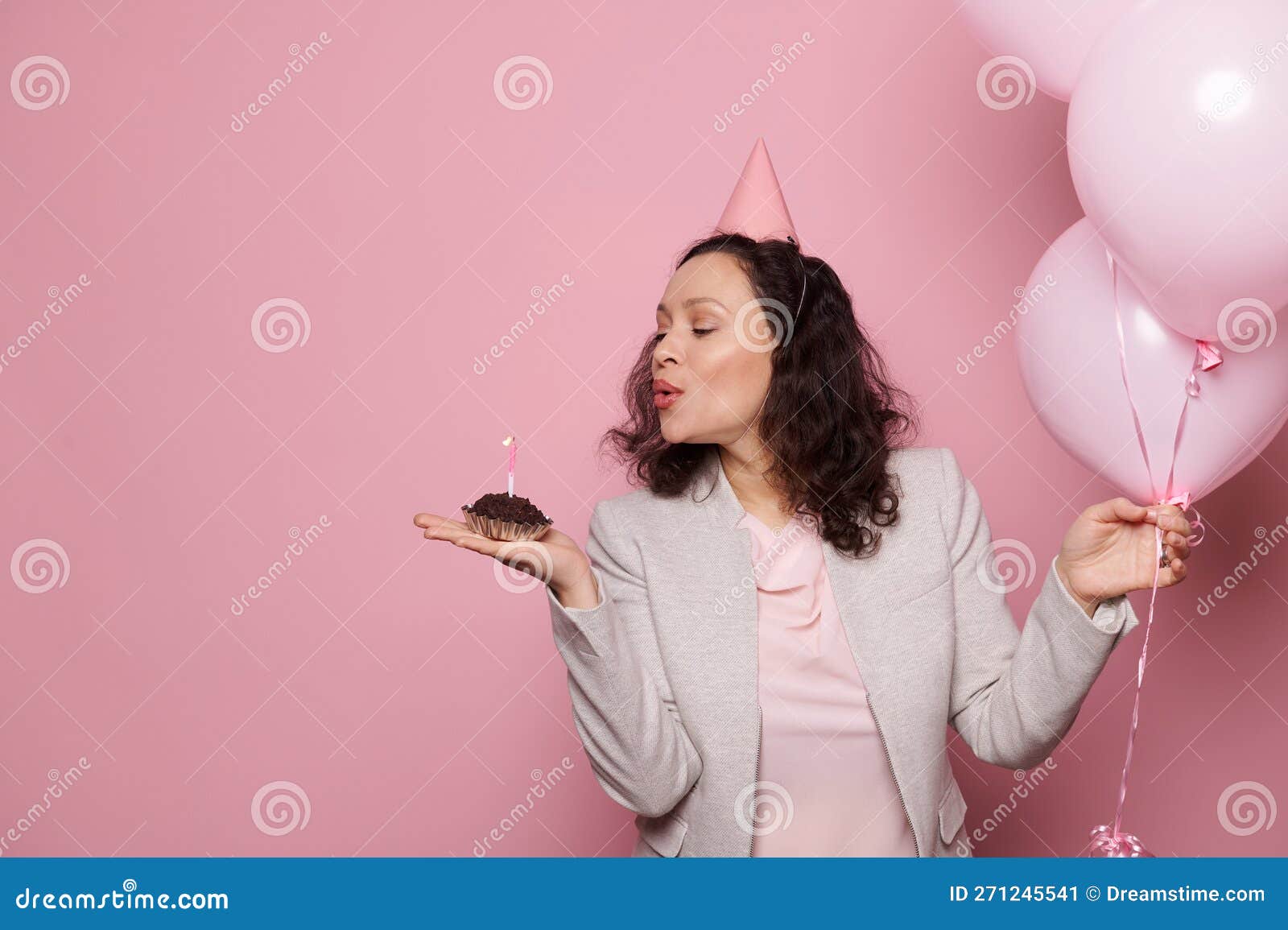 Charming lady with wavy hair looks into camera with smile and poses among  balloons on golden backgr 12754332 Stock Photo at Vecteezy