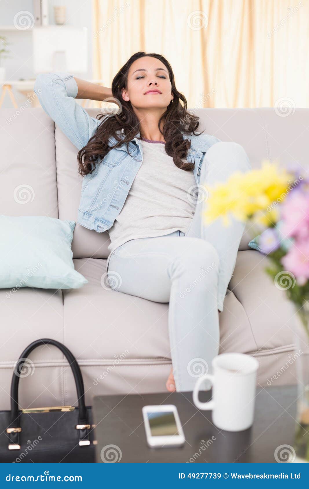 Pretty brunette relaxing on the couch at home in the living room