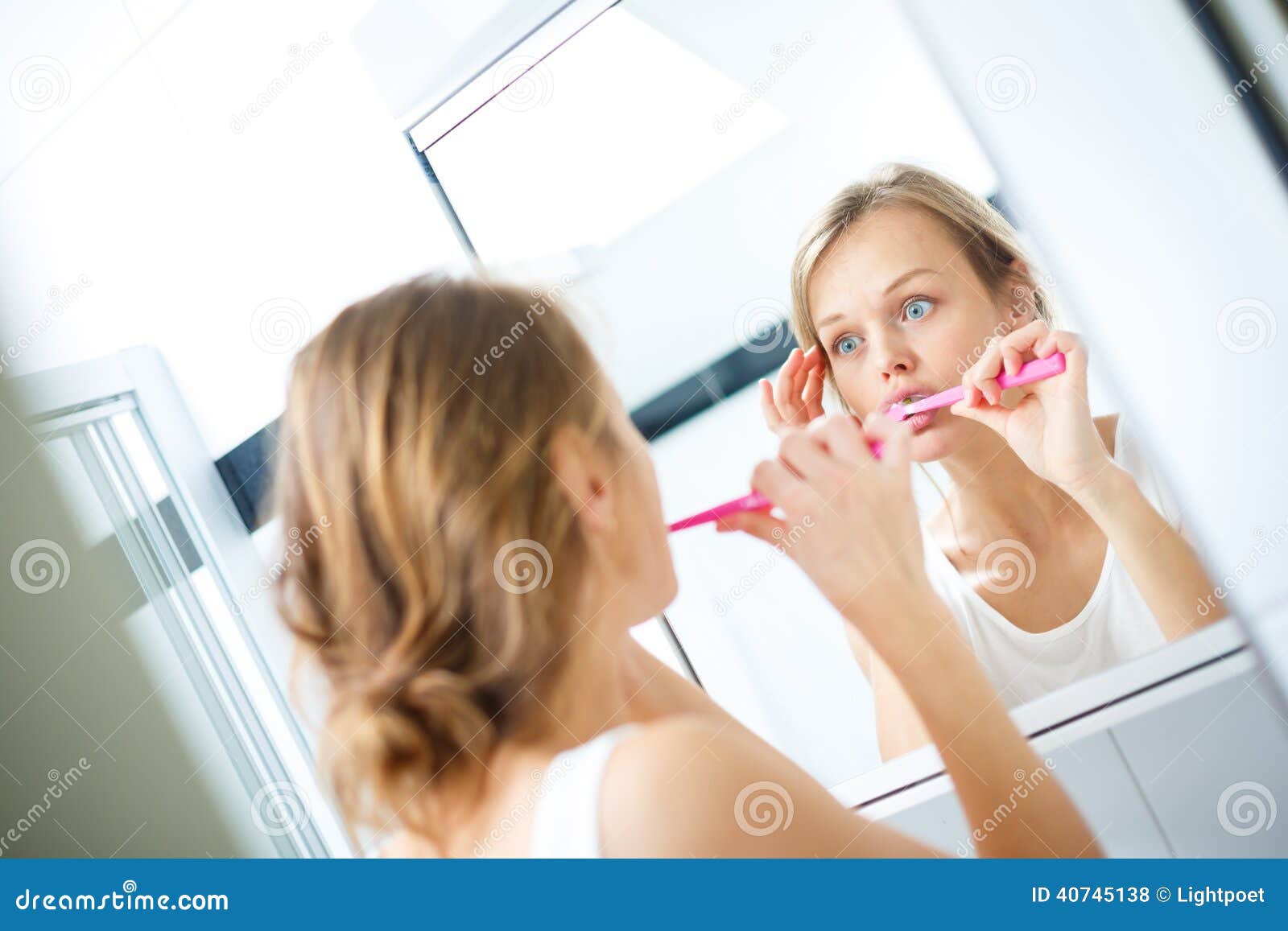 Pretty Female Brushing Her Teeth in Front of Mirror Stock Photo Image
