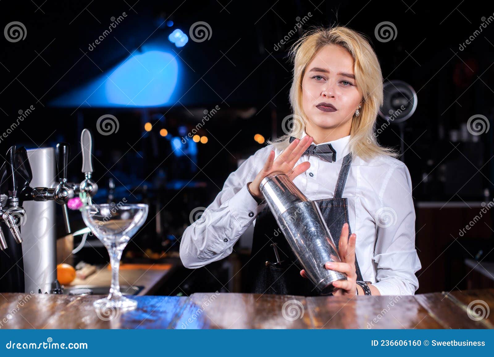 expert girl barman demonstrates the process of making a cocktail in the pub