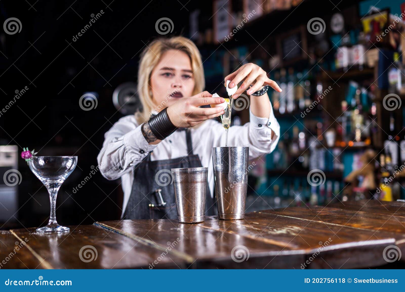 Pretty Girl Bartending Makes a Cocktail while Standing Near the Bar ...