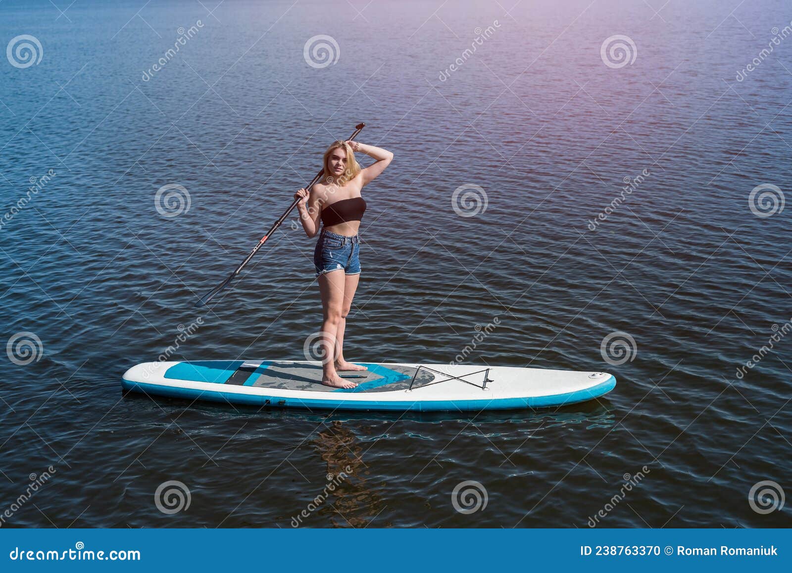 Pretty Girl Lying on Paddle Board on Dark Blue Pond Water Stock Photo ...