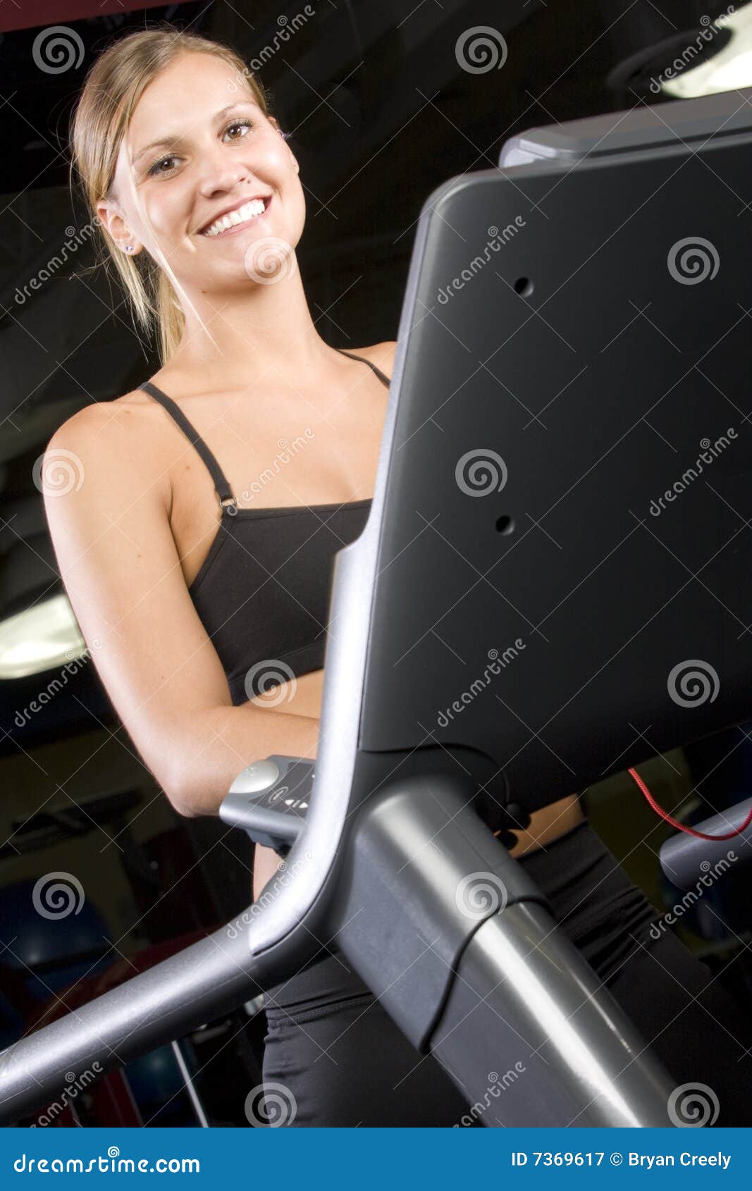 Pretty girl on a treadmill stock image. Image of floor 7369617