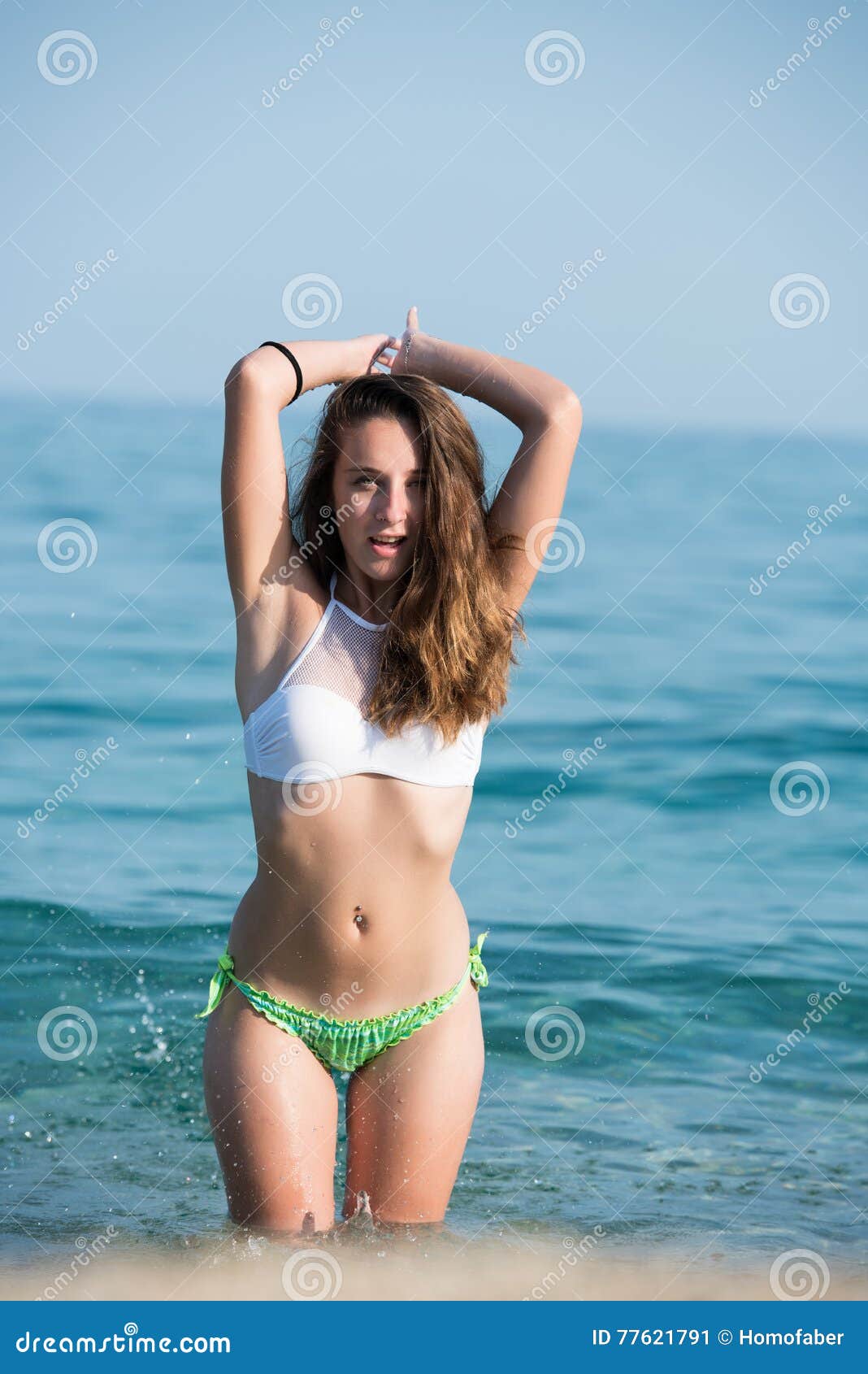 pretty girl wear bikini playing water kneeling sea vertical full body length photo 77621791