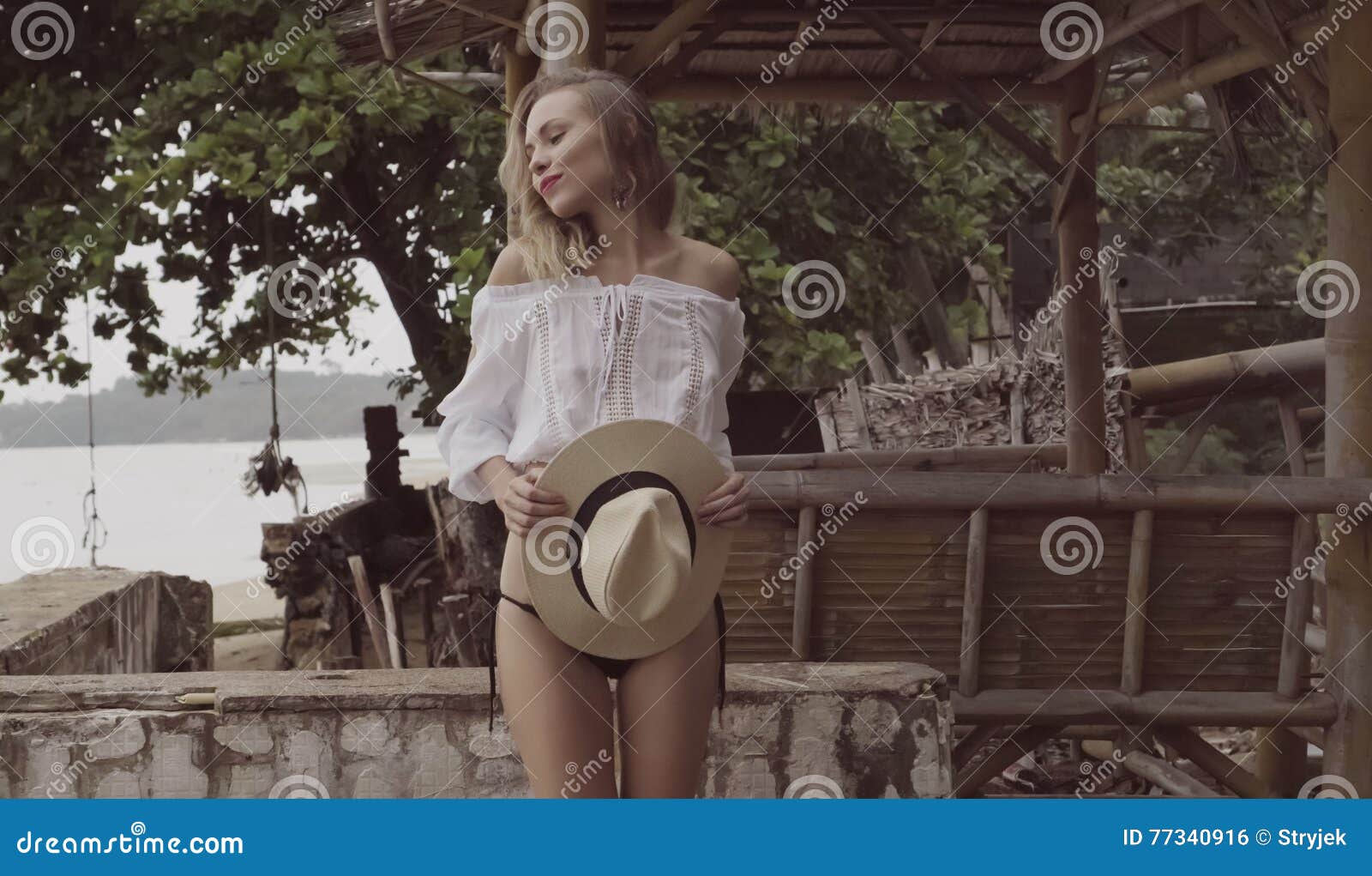 pretty naturally looking woman on summer day with straw hat
