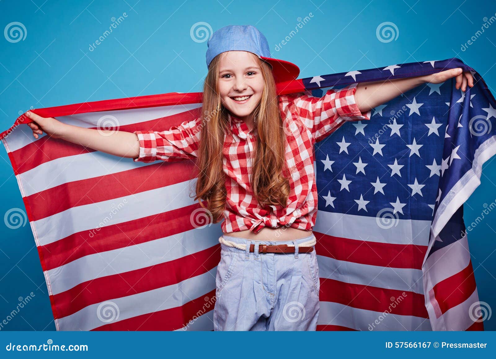 Pretty patriot. Cheerful American girl with stars-and-stripes looking at camera