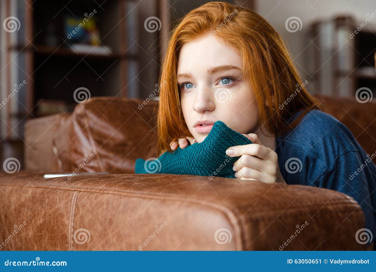 Pretty Pensive Redhead Girl Lying On Sofa And Thinking Stock Image