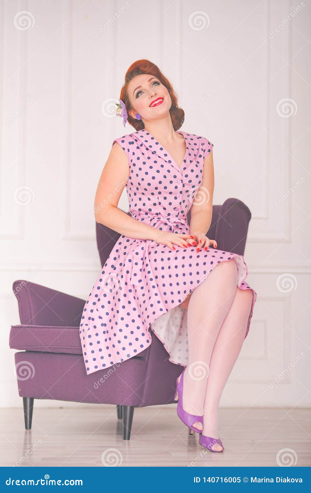 Pretty Redheaded Pin Up Woman Wearing Pink Polka Dot Dress And Posing
