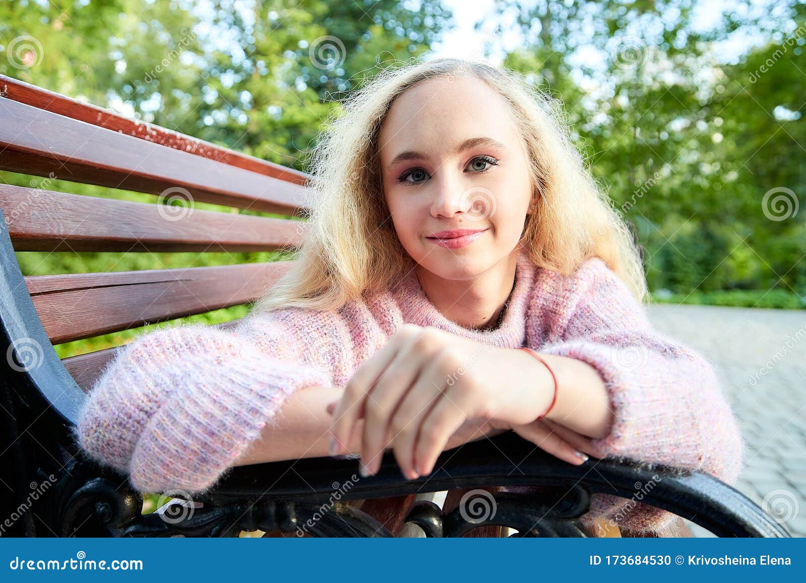 Pretty Teenage Girl 14 16 Year Old With Curly Long Blonde Hair In The Green Park On The Bench In 