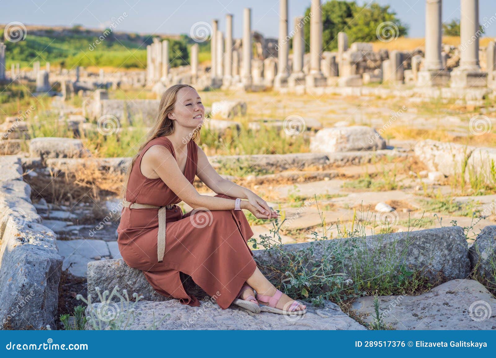 pretty tourist woman at the ruins of ancient city of perge near antalya turkey