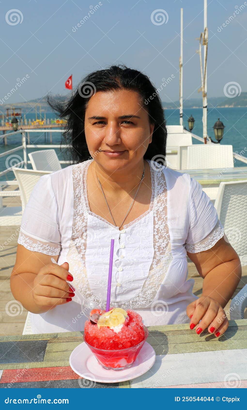 pretty turkish woman with white dress eating turkish dessert bici bici