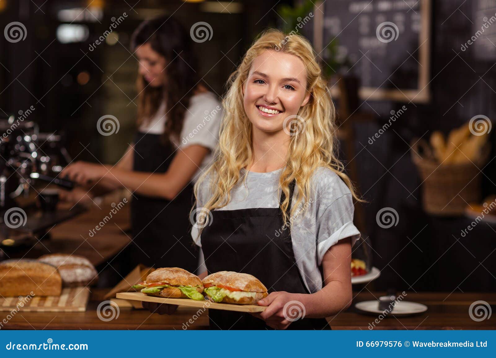 pretty waitress holding a tray with sandwiches