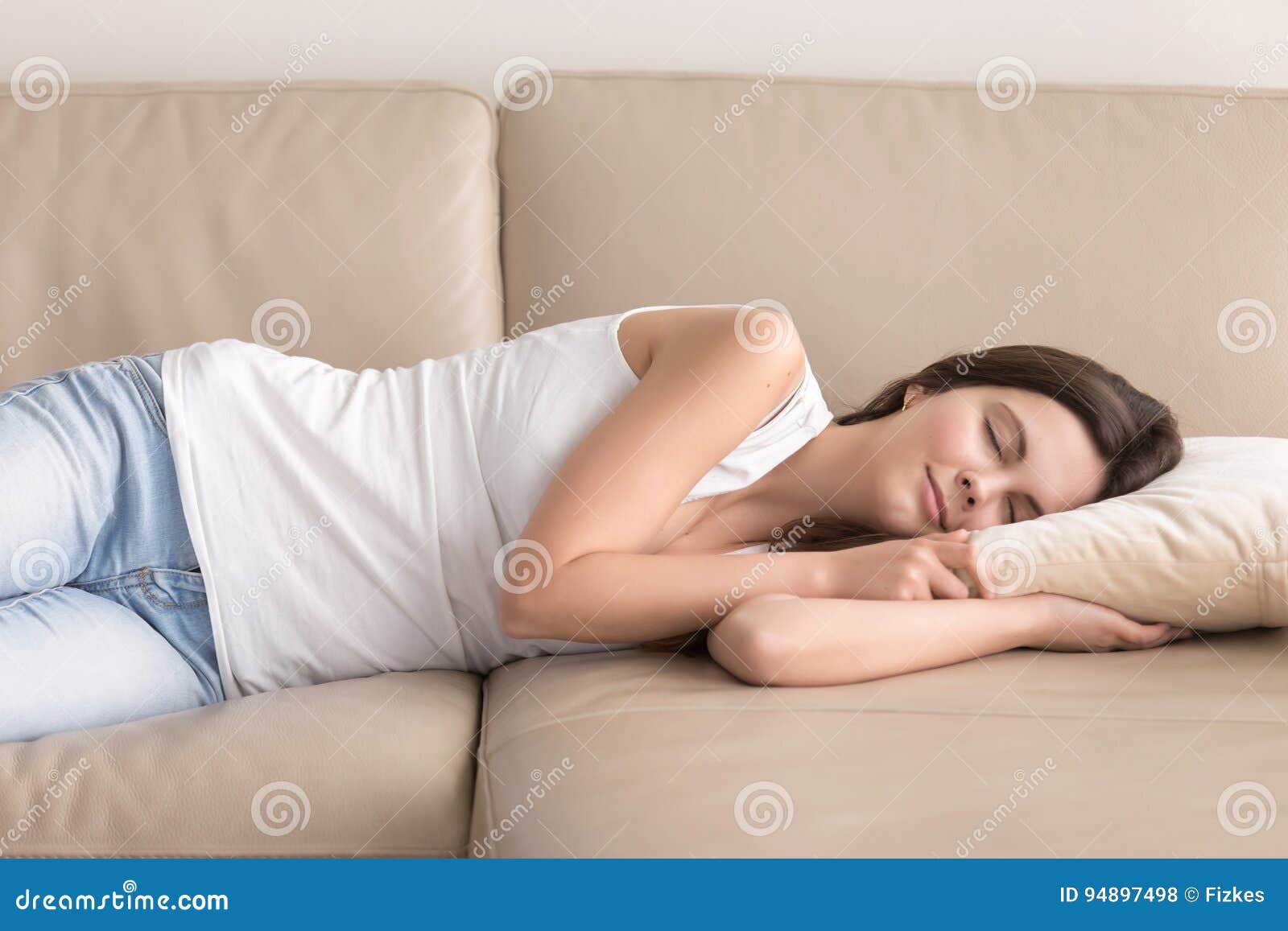 pretty woman takes short nap during day on sofa