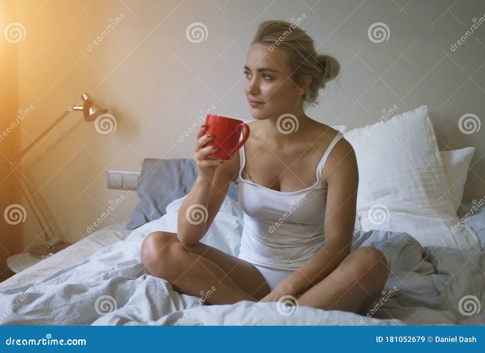 Pretty Woman In White Tank Top And Panties Sitting On Bed And Enjoying Hot Beverage Stock Image 