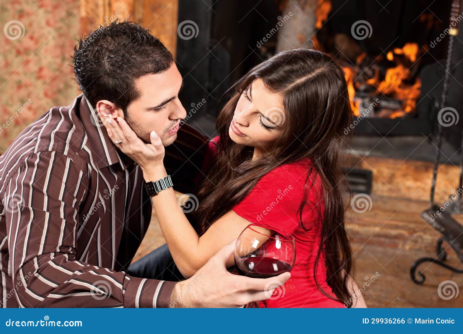 woman caress her man near fireplace