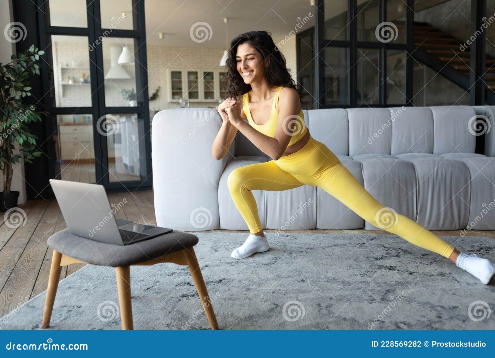 Pretty Young Woman in Sportswear Exercising at Home, Watching Video