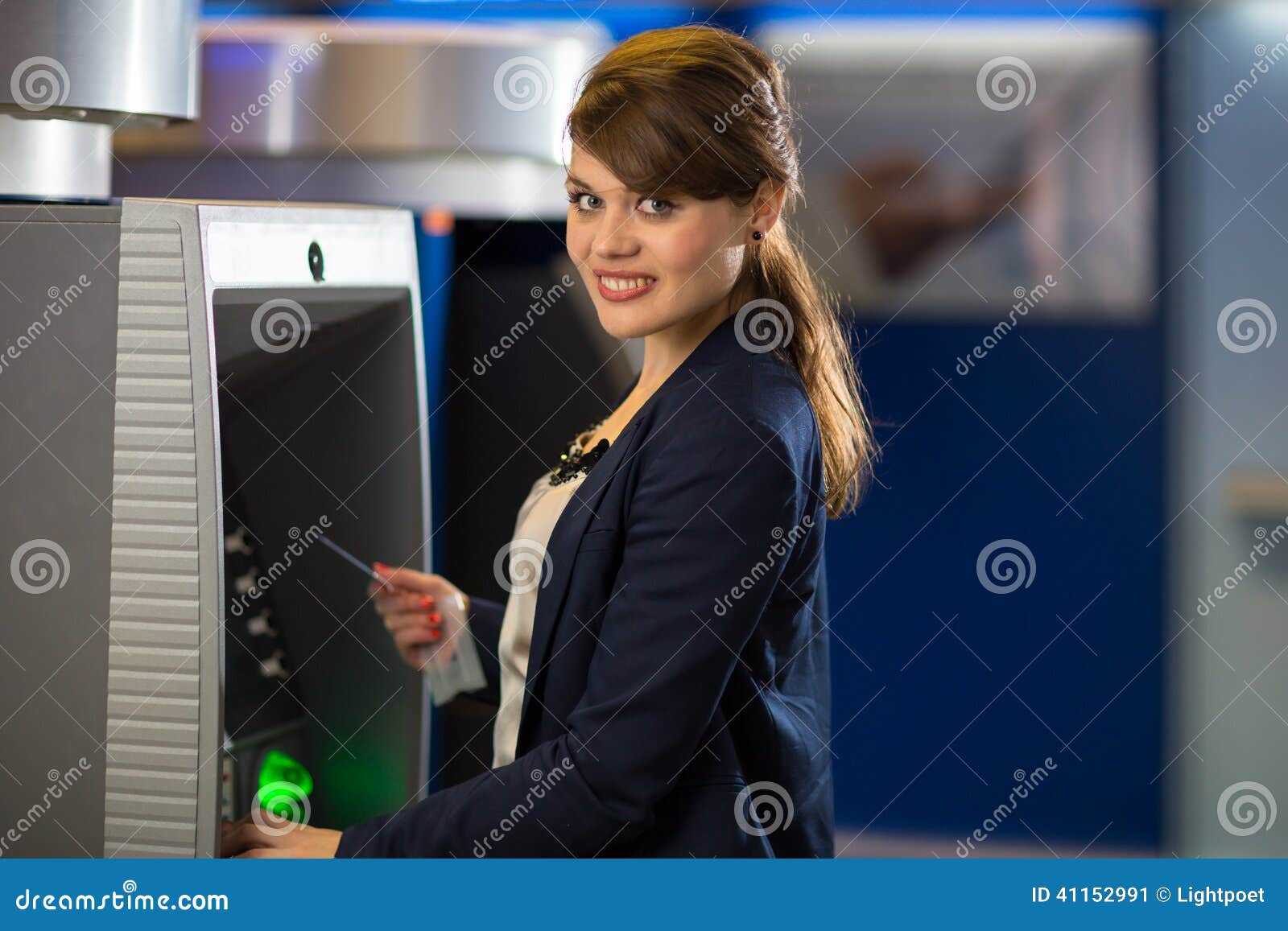 pretty, young woman withdrawing money from her credit card