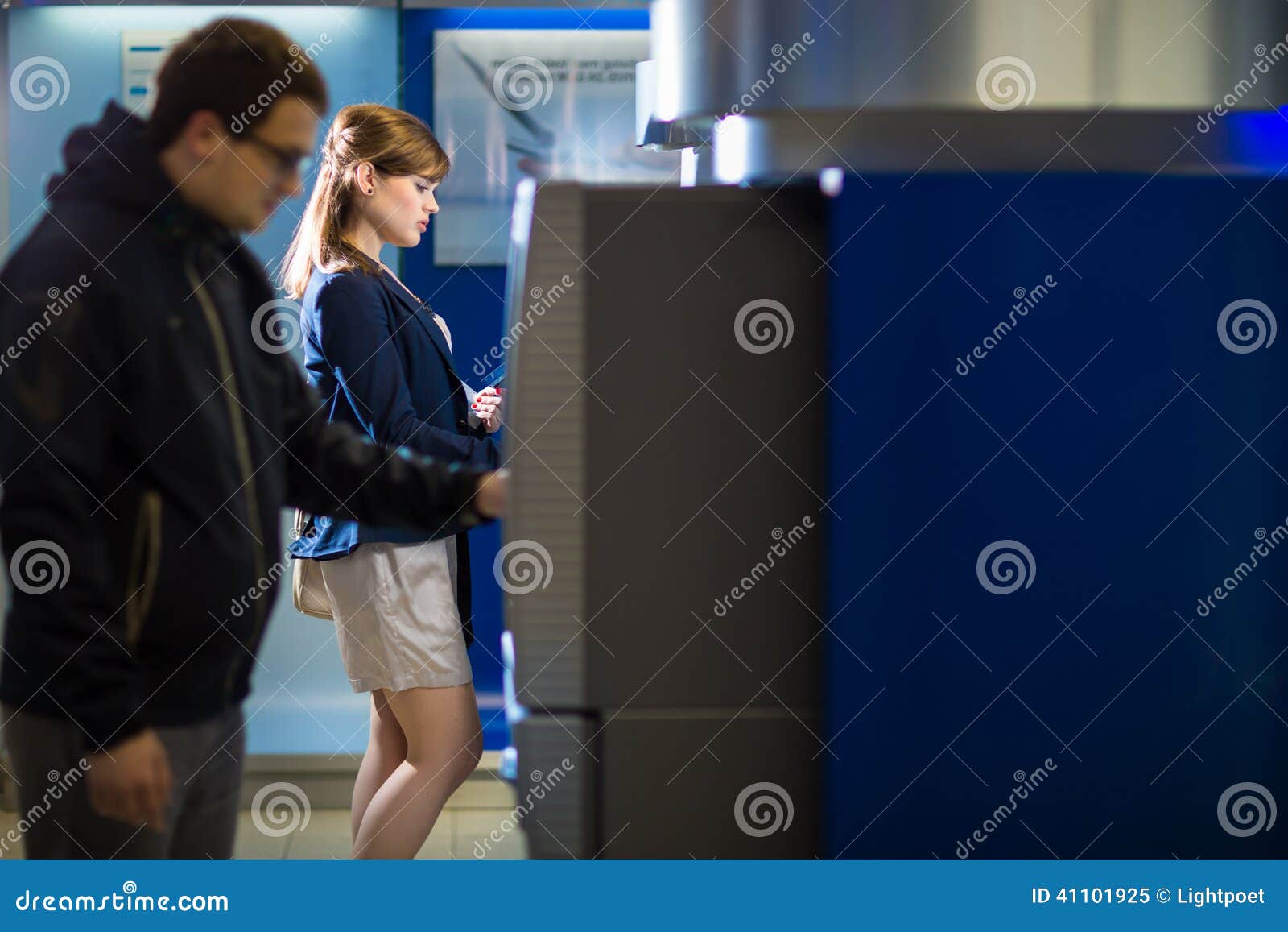 pretty, young woman withdrawing money from her credit card