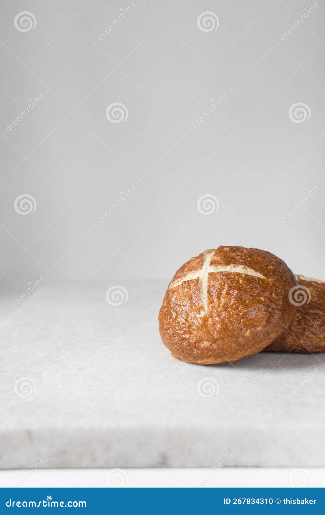 pretzel buns on a white marble tray