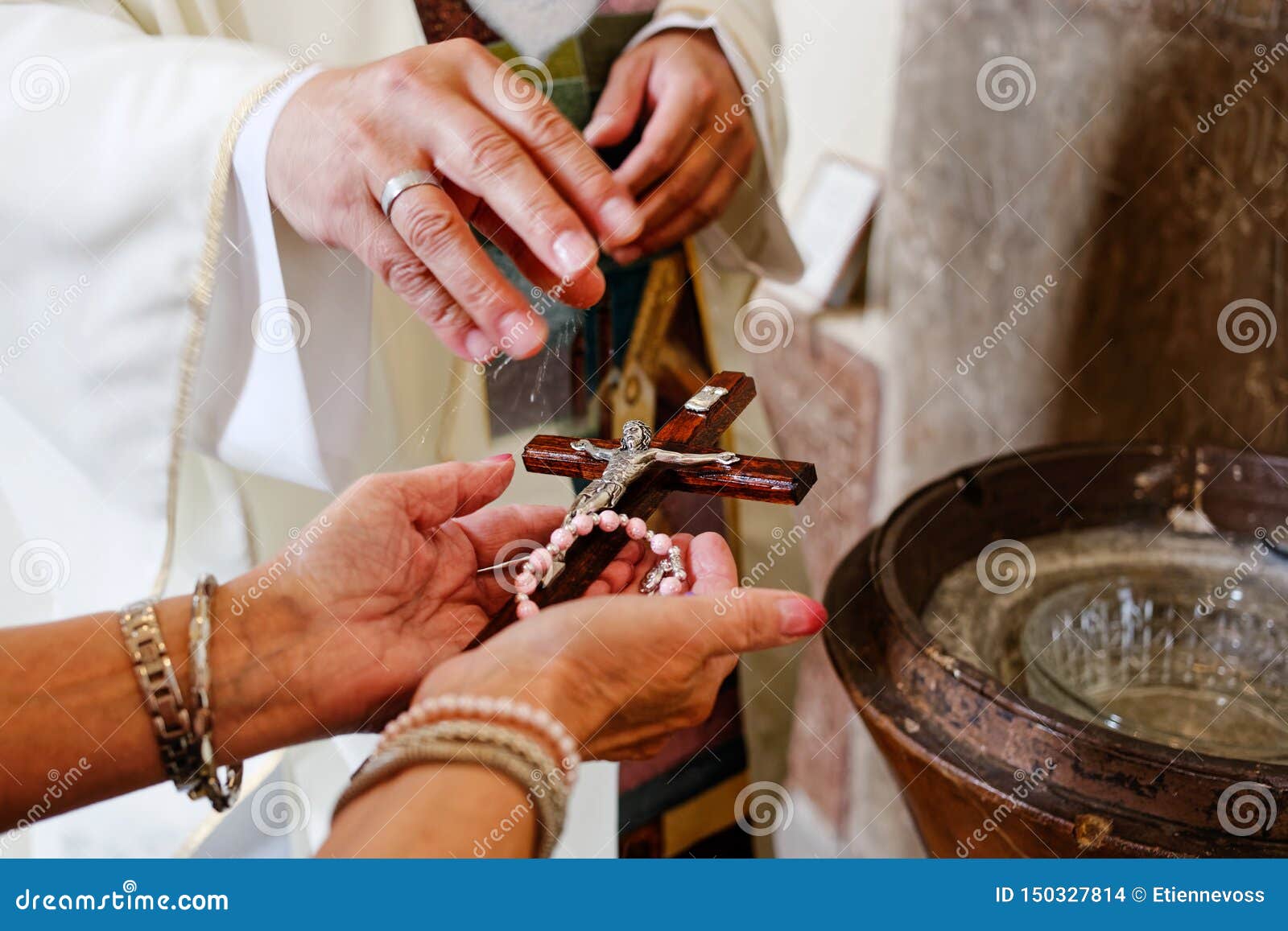 A Priest Blessing Rosary and Crucifix with Holy Water Stock Photo