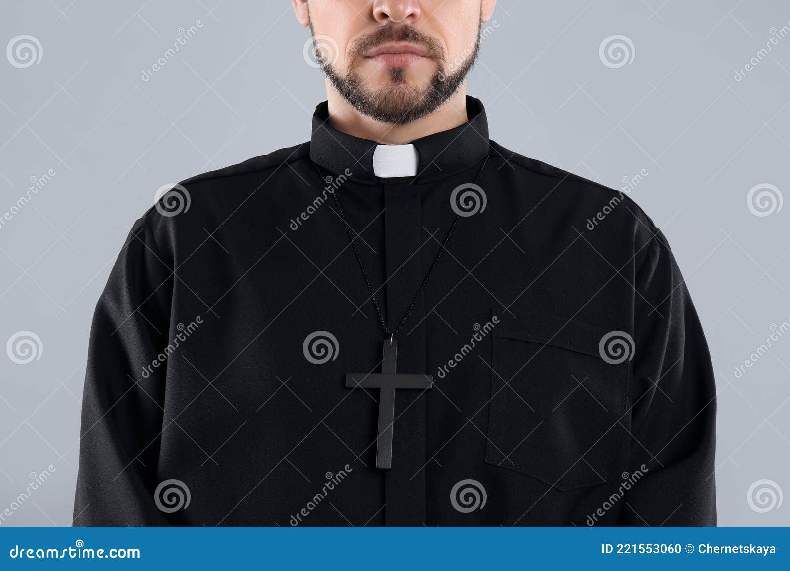 priest wearing cassock with clerical collar on grey, closeup