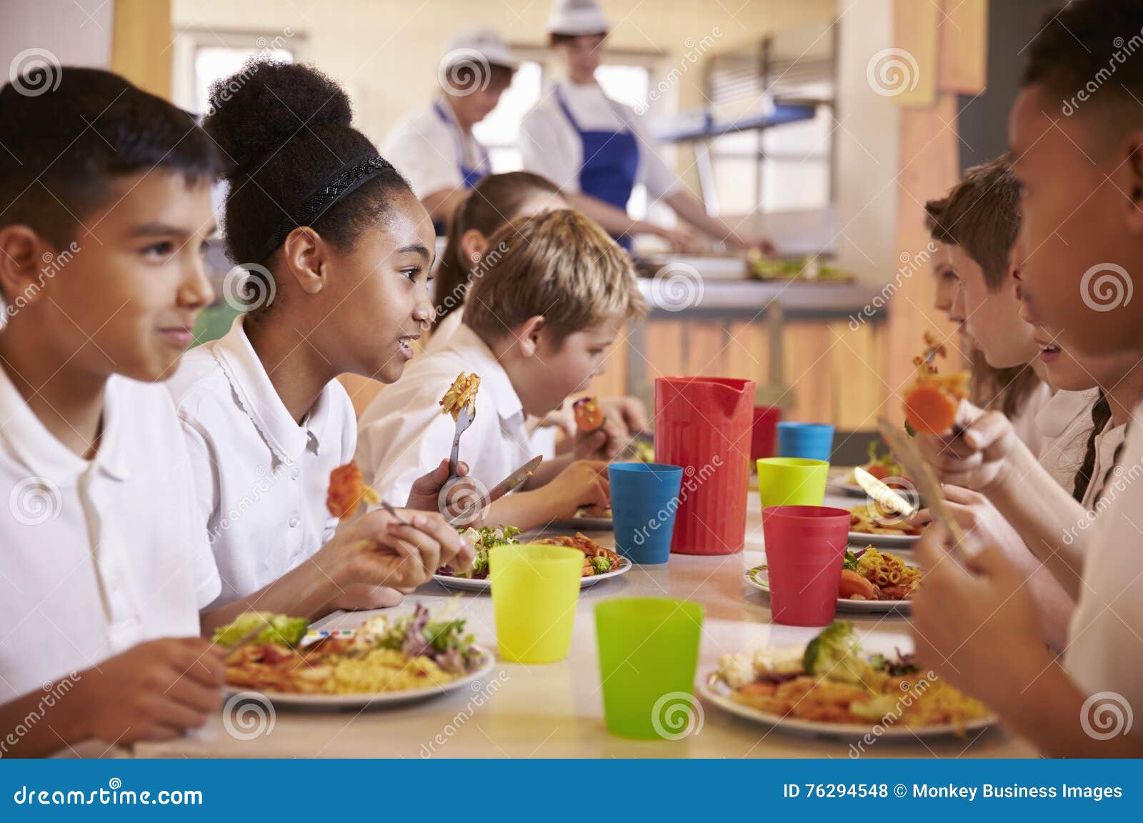 primary school kids eat lunch in school cafeteria, close up