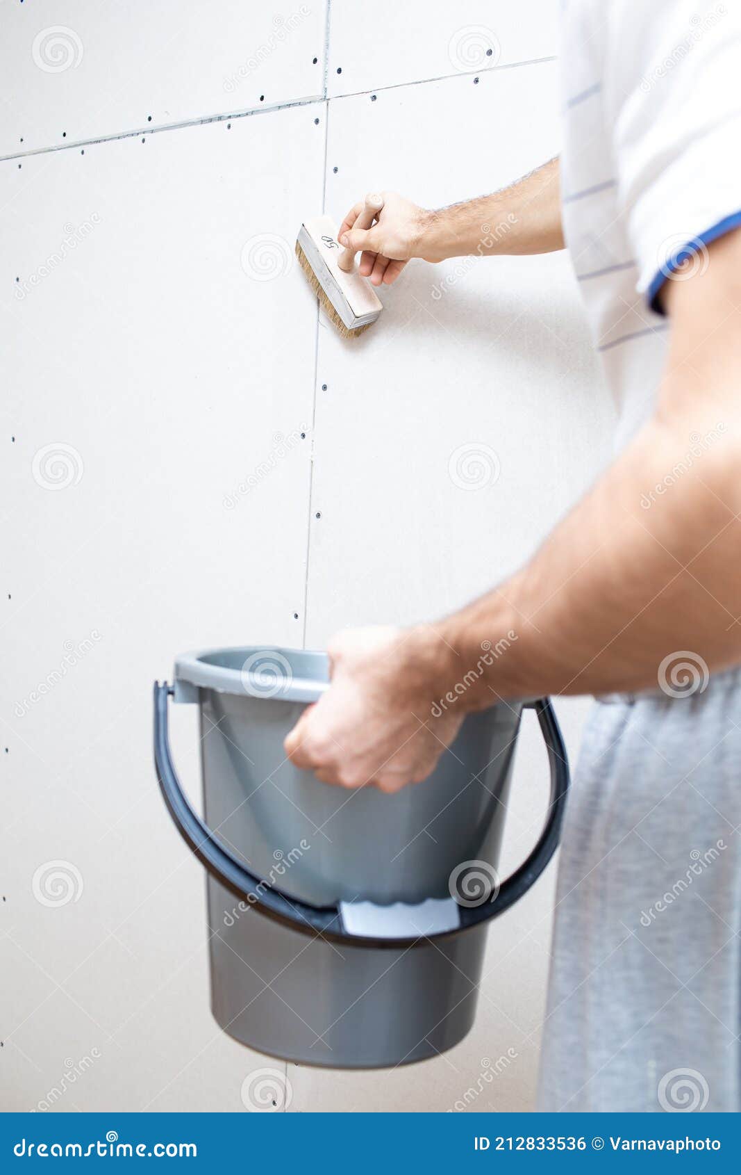 Priming the Wall with a Brush for Renovation Work. Preparing the Wall