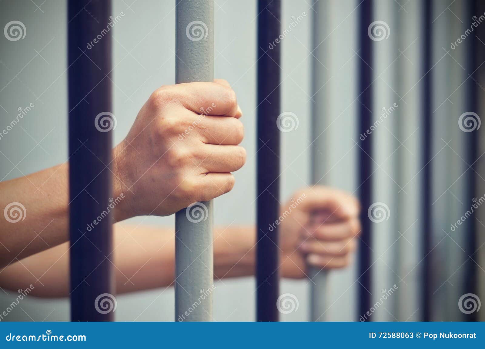 prisoner was locked in jail, hands hold captive iron bars that i