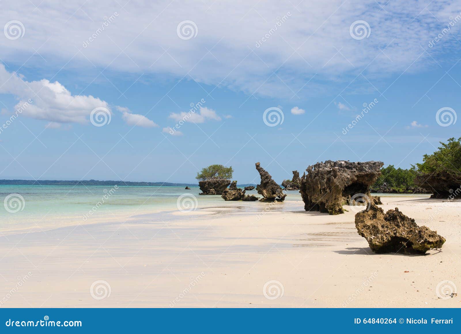 pristine white tropical beach with rocks, blue sea and lush vegetation on the african island of misali, pemba, zanzibar.