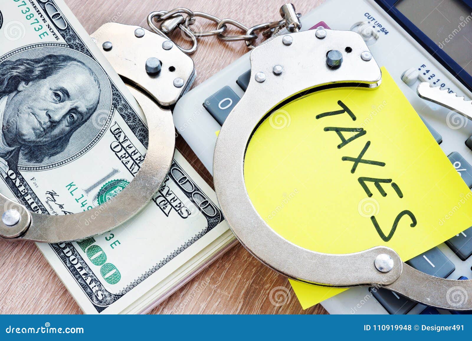 problems with taxes. handcuffs and money. tax evasion concept.