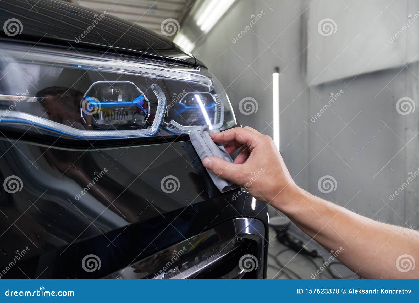 the process of applying a nano-ceramic coating on the car`s bumper by a male worker with a sponge and special chemical compositio