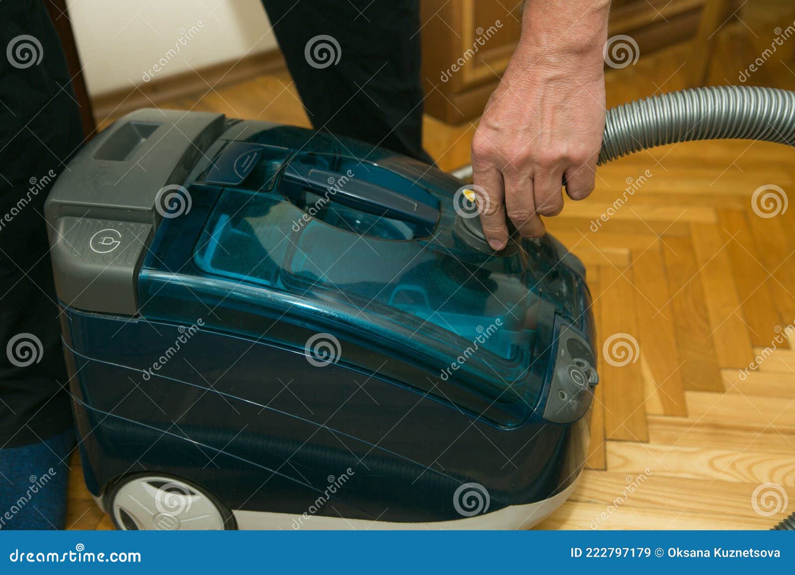 The Process of Cleaning a Room with a Vacuum Cleaner with an Aquafilter. Hands of a Man
